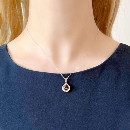 Woman wearing silver Circle Necklace with Picture Inside projecting a wedding photo onto a wall.
