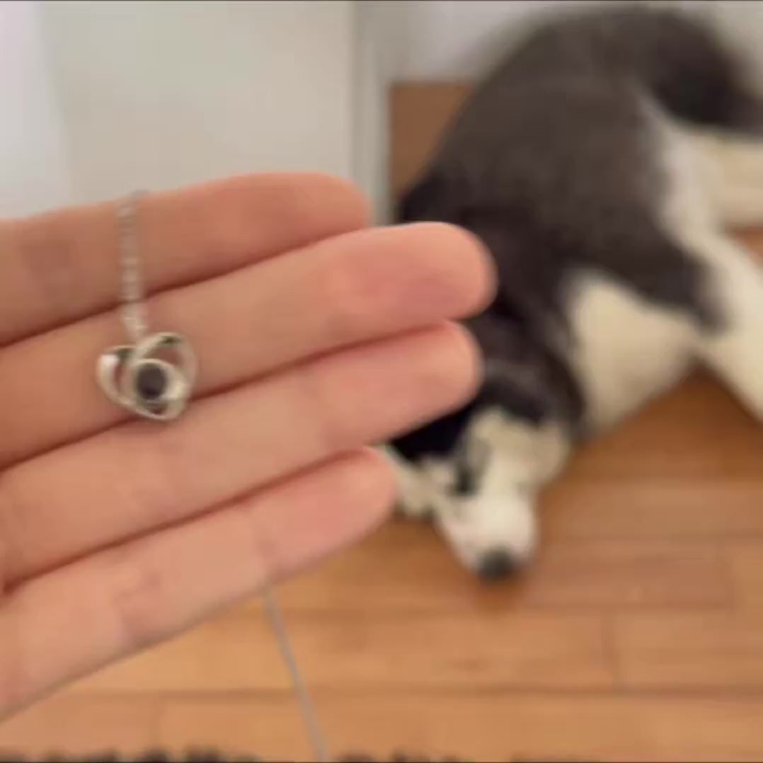Woman wearing a custom heart projection necklace with her dog's picture inside 