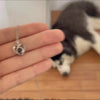 Woman wearing a custom heart projection necklace with her dog's picture inside 