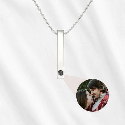 A vertical bar projection necklace for him in silver color.