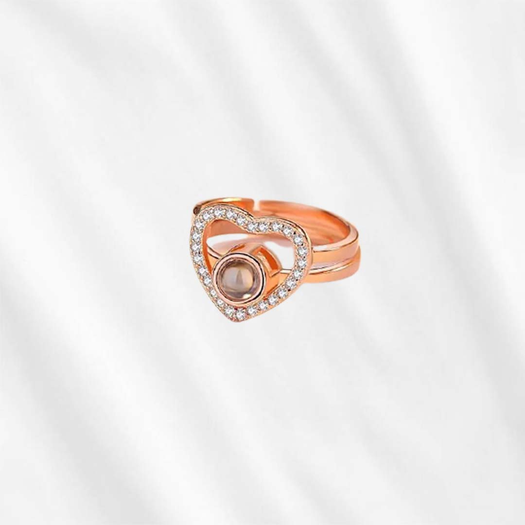 A heart projection ring is the best gift to say "I love you". The central stone, which keeps a personalized picture inside, is accented by simmering zircon stones. A forever classic to wear everday.